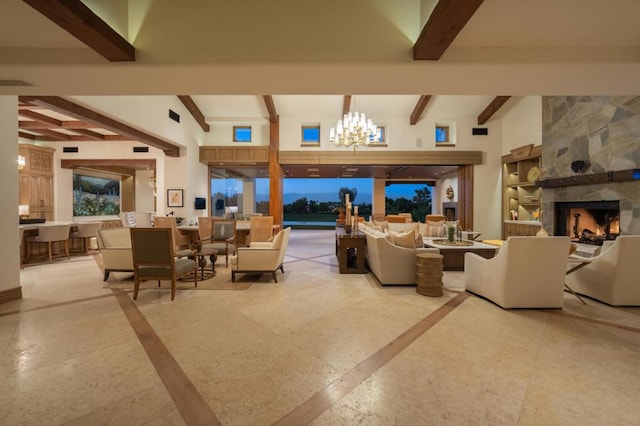 living room with beamed ceiling, a fireplace, a towering ceiling, and a chandelier