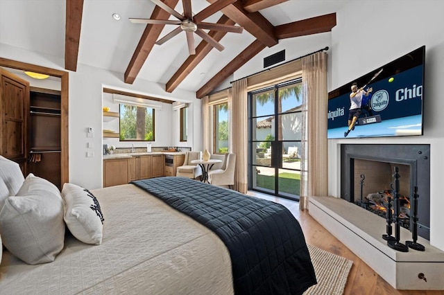 bedroom with light wood-type flooring, vaulted ceiling with beams, ceiling fan, and access to outside