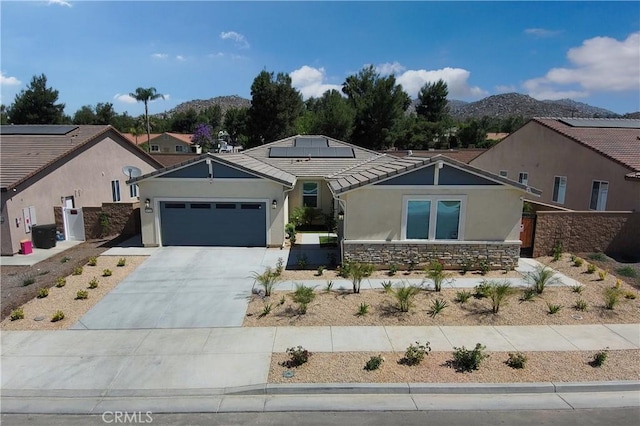 view of front facade featuring a mountain view, a garage, and solar panels