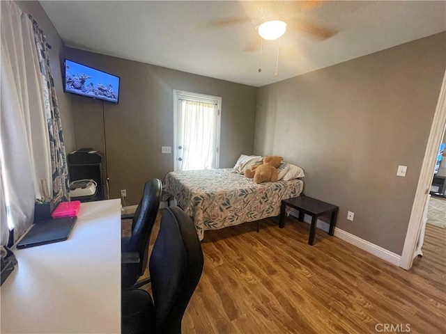 bedroom featuring ceiling fan, baseboards, and wood finished floors