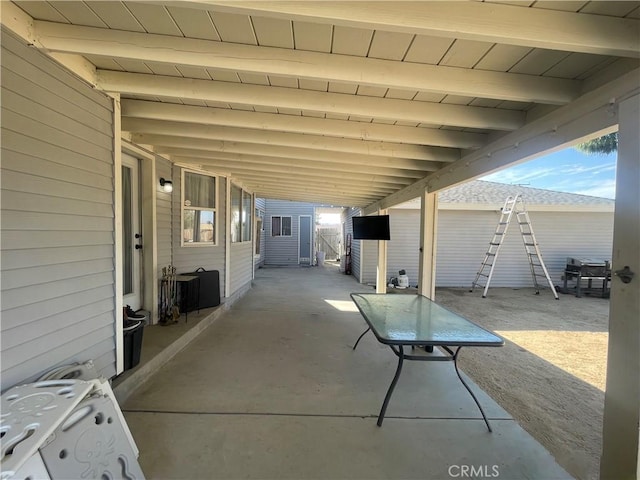 view of patio with an outbuilding, fence, and a shed