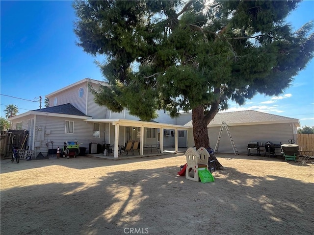 rear view of house with a patio area and fence