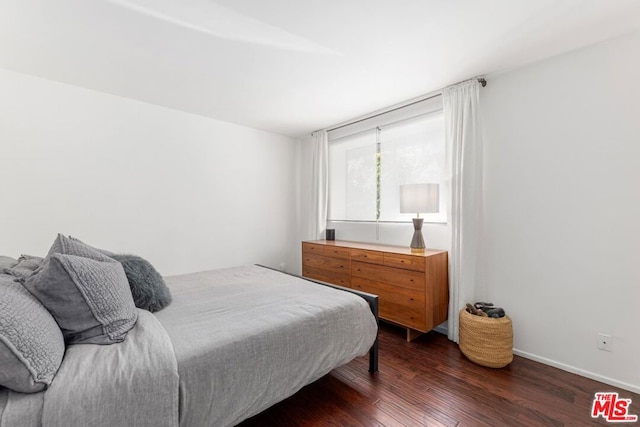 bedroom with dark hardwood / wood-style floors