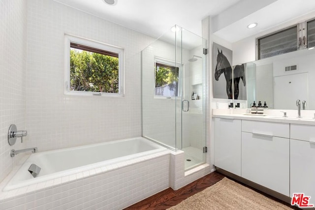 bathroom featuring vanity, independent shower and bath, and wood-type flooring