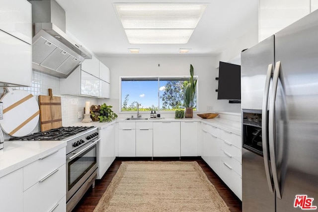 kitchen with wall chimney exhaust hood, sink, tasteful backsplash, stainless steel appliances, and white cabinets