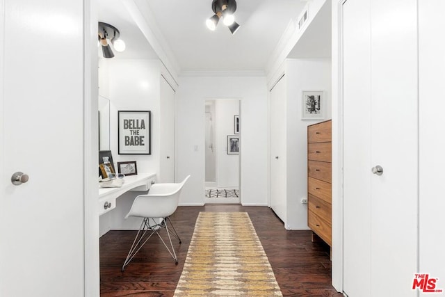 home office featuring dark hardwood / wood-style flooring, built in desk, and ornamental molding