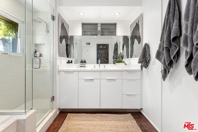 bathroom featuring hardwood / wood-style flooring, vanity, and walk in shower