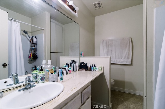 bathroom featuring curtained shower, vanity, and toilet