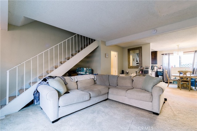 carpeted living room with a notable chandelier and a textured ceiling