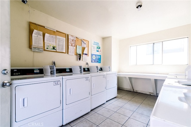 clothes washing area with light tile patterned floors and independent washer and dryer