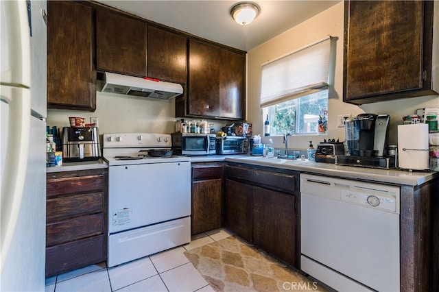 kitchen with dark brown cabinets, light tile patterned floors, and white appliances