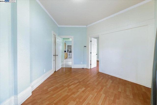 empty room featuring hardwood / wood-style flooring and ornamental molding