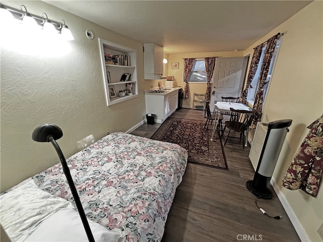 bedroom featuring dark hardwood / wood-style floors and a wood stove