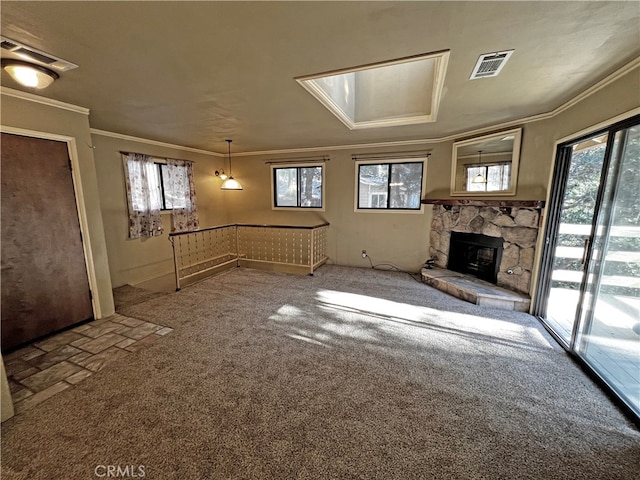 unfurnished living room with crown molding, a stone fireplace, and carpet flooring