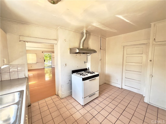 kitchen featuring sink, gas range gas stove, extractor fan, white cabinetry, and light hardwood / wood-style floors