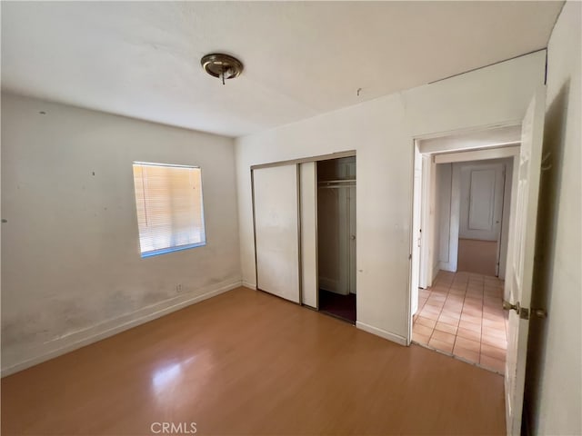 unfurnished bedroom featuring light wood-type flooring and a closet