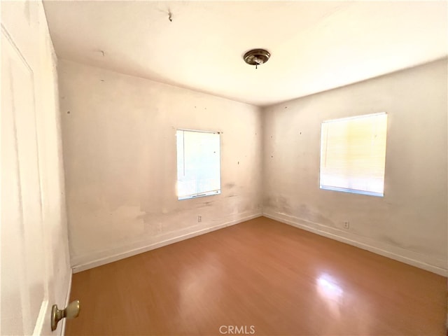 unfurnished room featuring a wealth of natural light and hardwood / wood-style floors