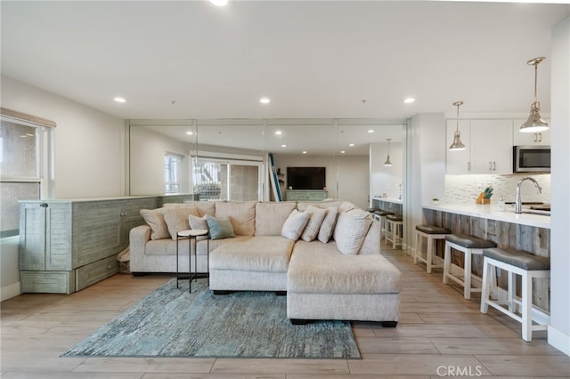 living room featuring sink and light hardwood / wood-style floors