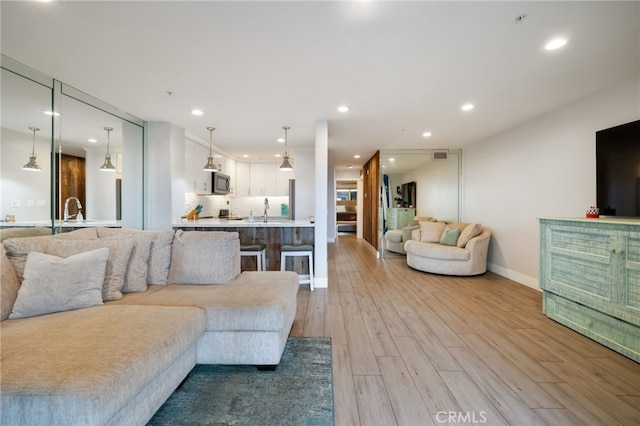 living room featuring light wood-type flooring and sink