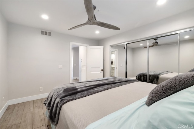 bedroom with ceiling fan, a closet, and light hardwood / wood-style flooring