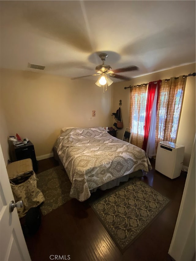 bedroom with dark hardwood / wood-style flooring and ceiling fan