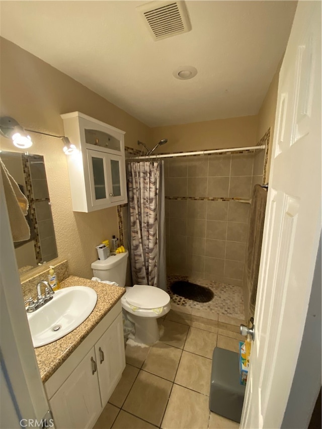 bathroom with toilet, vanity, curtained shower, and tile patterned flooring