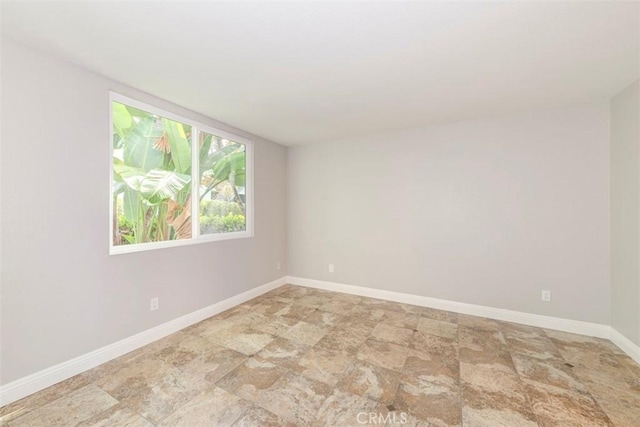 unfurnished room with baseboards