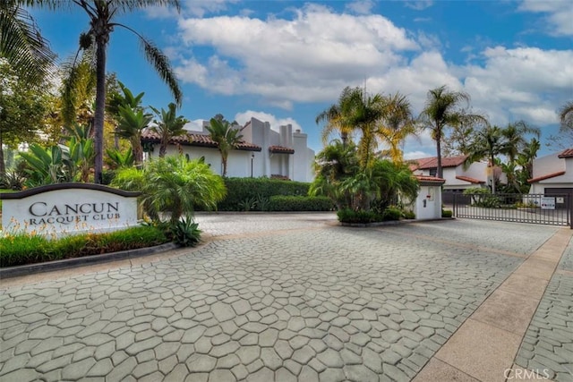 exterior space with a gate, curbs, and a gated entry