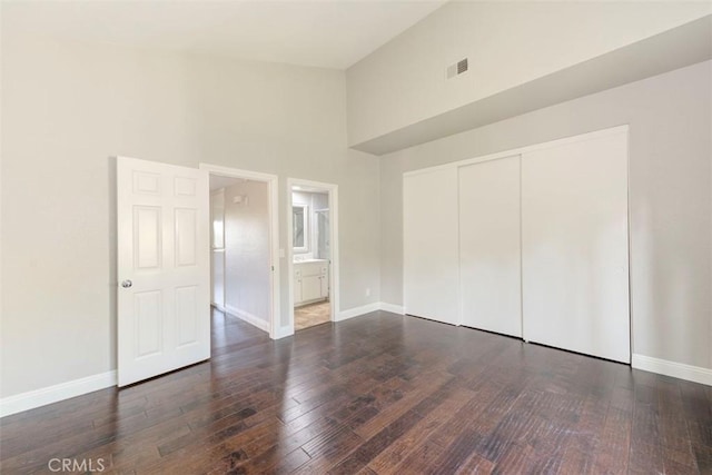 unfurnished bedroom featuring hardwood / wood-style flooring, baseboards, and visible vents