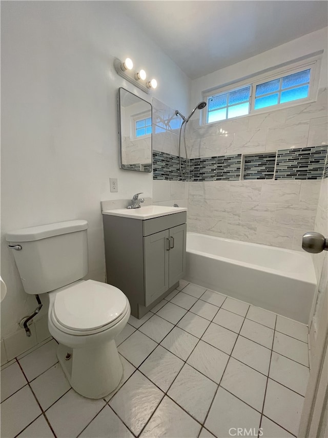 full bathroom featuring tiled shower / bath combo, vanity, toilet, and tile patterned floors