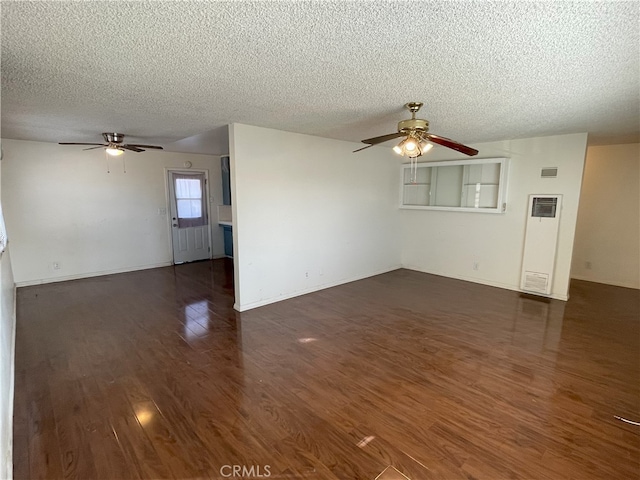 unfurnished living room featuring ceiling fan, dark wood-type flooring, and a textured ceiling