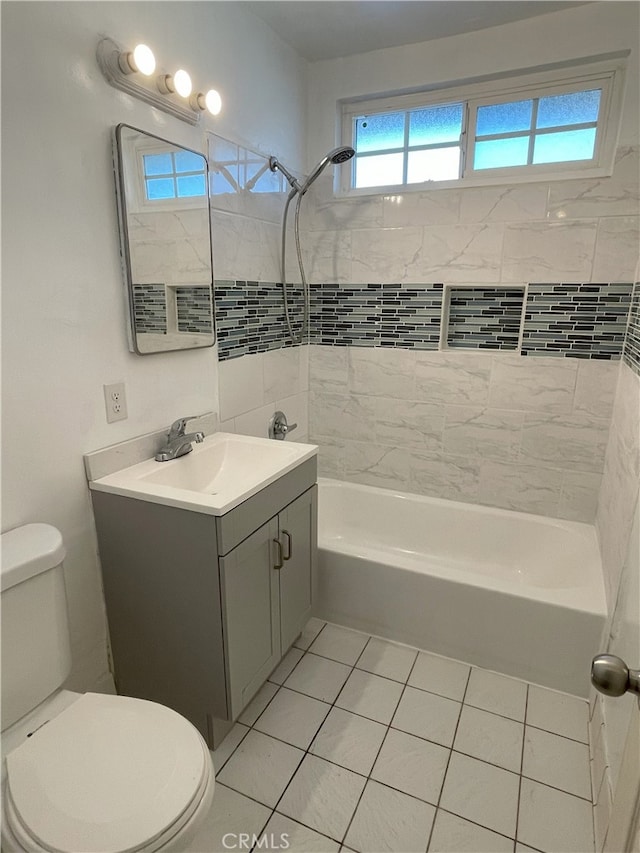 full bathroom featuring toilet, vanity, tile patterned flooring, and tiled shower / bath combo