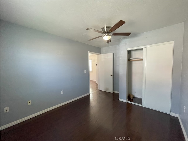 unfurnished bedroom with ceiling fan, dark hardwood / wood-style floors, and a closet