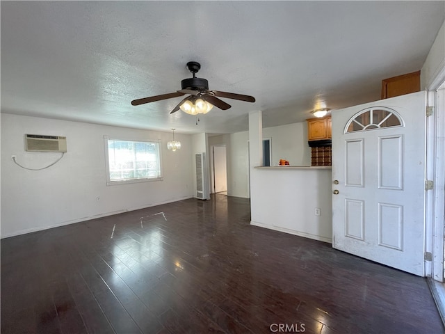 unfurnished living room with an AC wall unit, ceiling fan, dark hardwood / wood-style flooring, and a textured ceiling