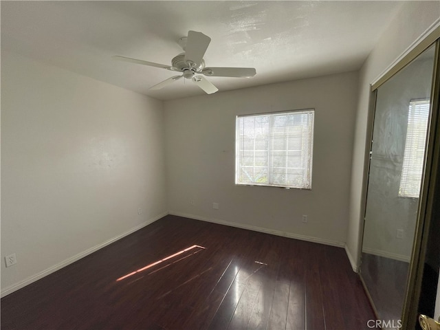 empty room featuring dark hardwood / wood-style flooring and ceiling fan