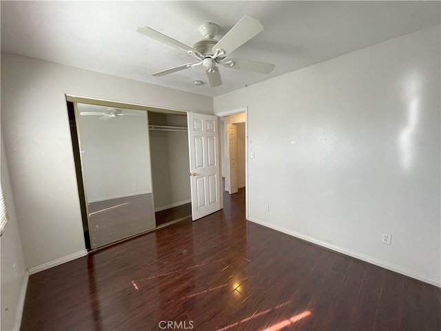 unfurnished bedroom with dark hardwood / wood-style flooring, ceiling fan, and a closet