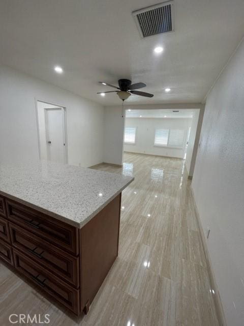interior space with light stone countertops, a ceiling fan, visible vents, and recessed lighting