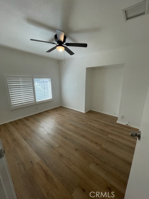 unfurnished room with ceiling fan and dark hardwood / wood-style flooring