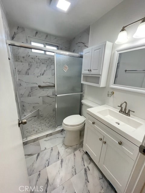 bathroom featuring vanity, toilet, and an enclosed shower