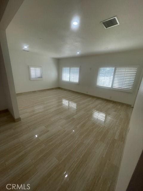 unfurnished room featuring baseboards, wood finished floors, visible vents, and recessed lighting