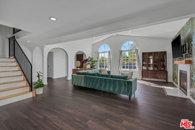 living room with lofted ceiling, dark hardwood / wood-style floors, and a large fireplace