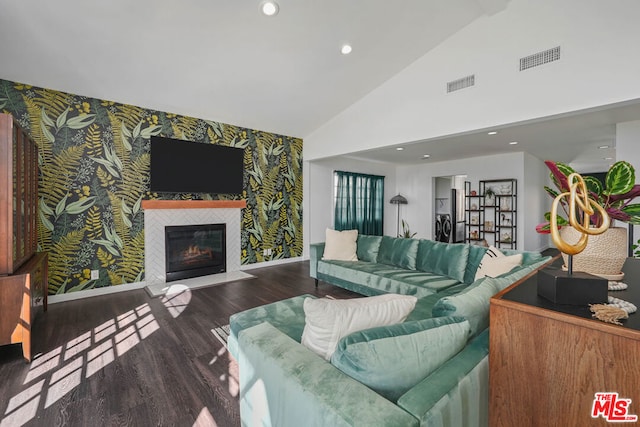 living room with a fireplace, dark hardwood / wood-style flooring, and high vaulted ceiling