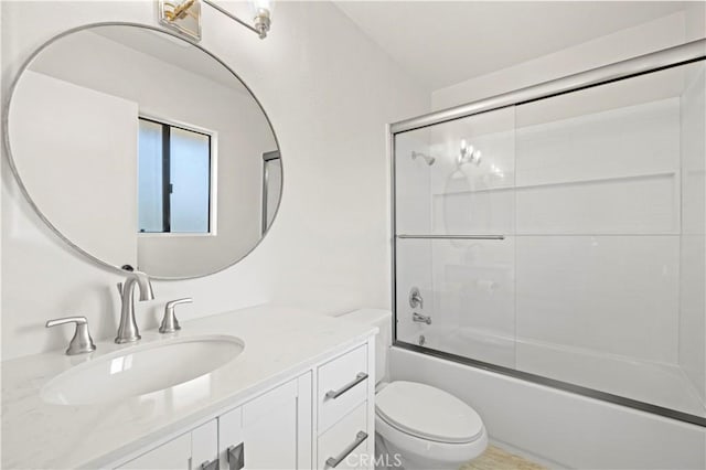 full bathroom with vanity, toilet, and shower / bath combination with glass door