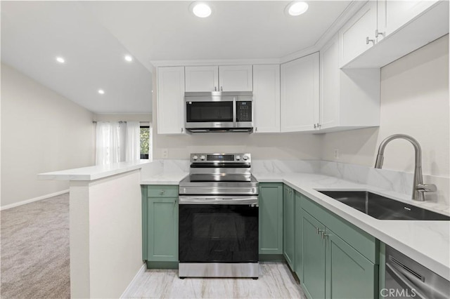 kitchen featuring sink, green cabinetry, light colored carpet, white cabinetry, and stainless steel appliances