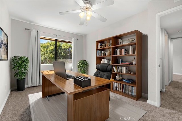 office space featuring light carpet and ceiling fan