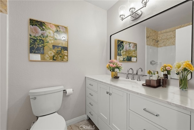 bathroom featuring vanity, toilet, and walk in shower