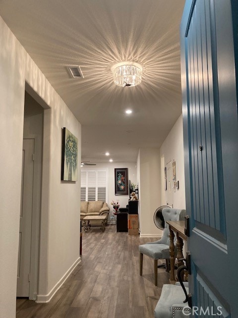 hallway with a notable chandelier and dark hardwood / wood-style floors