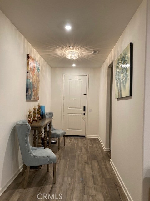 hall featuring a chandelier and dark hardwood / wood-style flooring