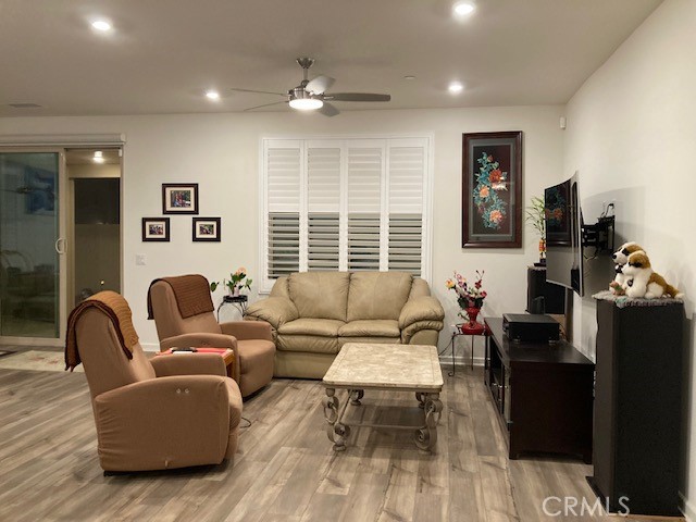 living room featuring light hardwood / wood-style floors and ceiling fan