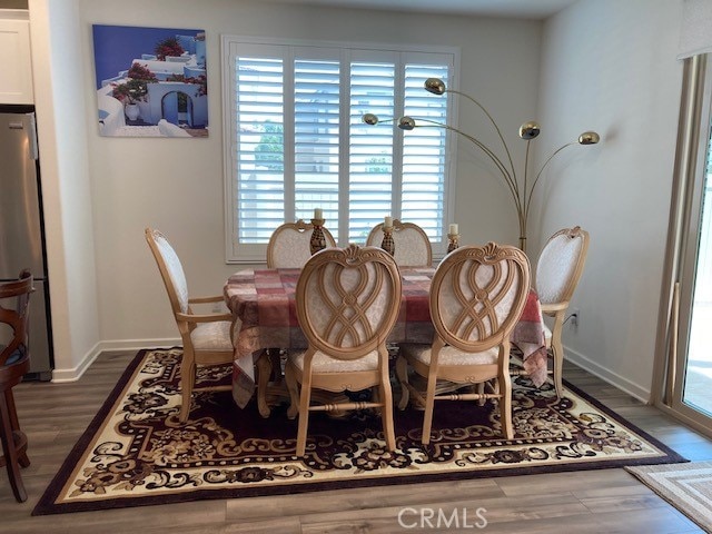 dining area with a healthy amount of sunlight and dark hardwood / wood-style floors